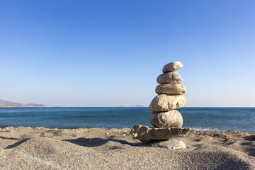 Turm aus Steinen am Strand mit Blick auf das Meer