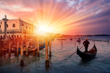 Gondolier vénitien en barque gondole à travers les eaux vertes du canal de Venise Italie