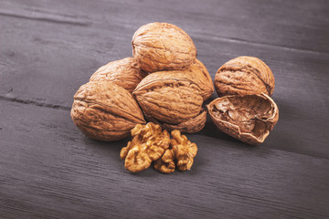 Walnut kernels and whole walnuts on old wooden table