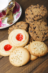 Delicious cookies placed on wooden table next to a cup of coffee. Horizontal studio shot.