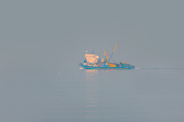 Fish boat floating in the fog