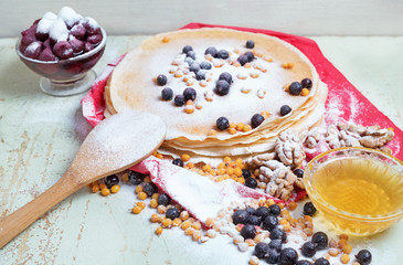 Carnival celebration, delicious pancakes close-up, with a fresh blueberry and sea buckthorn, cherries  honey.