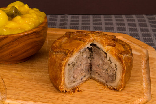 Game pie served with bowl of piccalilli