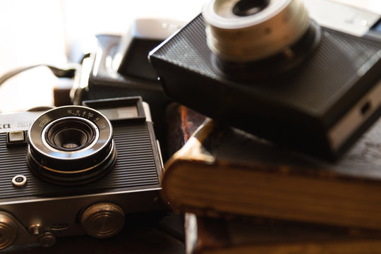 vintage camera close-up on wooden table on background of old books