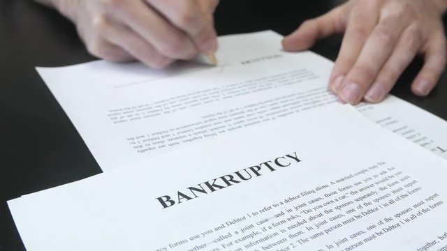 Signing a Bankruptcy document. Closeup on the legal paper.