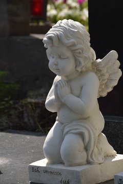 betende engelsfigur auf einem grab