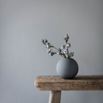 Vase on wooden table against gray wall