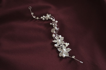 Hair jewellery tiara for weddings on red soft material background © naturalearth2
