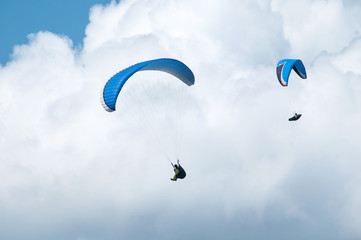 Paraglider flying in the sky. Paragliding. Paraglider flying near clouds.