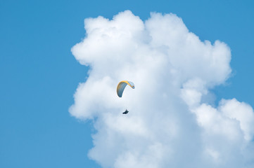 Paraglider flying in the sky. Paragliding. Paraglider flying near clouds.