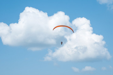 Paraglider flying in the sky. Paragliding. Paraglider flying near clouds.