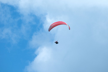 Paraglider flying in the sky. Paragliding. Paraglider flying near clouds.