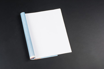 Mock-up magazine or catalog on black chalkboard. Blank page or notepad on black table background. Blank page or notepad for mockups or simulations.