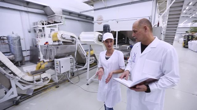 workers talk on the background of macaroni production