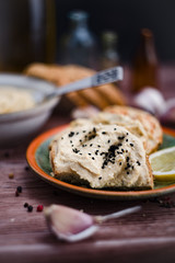 Sandwiches with hummus on the wooden board.