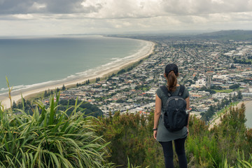 Young woman tourist enjoys the ocean view in Mt Maunganui