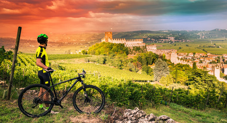 Fototapeta premium Cyclist admires the Soave castle views.