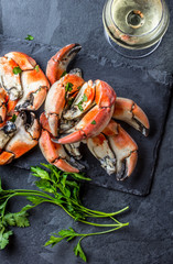 Crabs tentacles with wite wine, lemon, herbs sauce, slate background