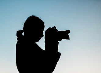 silhouette of a woman with camera