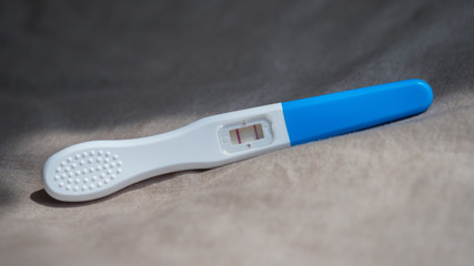 pregnancy test positive result on bed