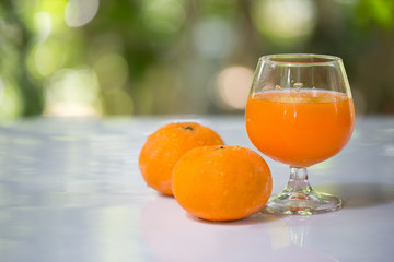 Fresh orange and orange juice in glass on white plate