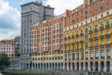 Fototapeta na wymiar House facades in Bilbao along the Nervion river that runs through the city into the Cantabrian Sea. The apartment blocks are situated in the districts San Frantzisko and Bilbao la Vieja