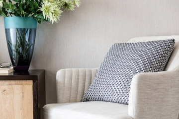 beige color upholstered chair in living room with flowers