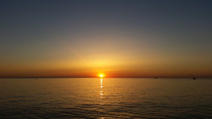 Fiery sunrise at Italian beach. Summer season. Emilia Romagna region. Adriatic sea. Italy