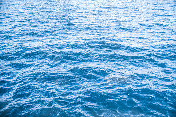 splits waves in the sea water dark blue lake surface .