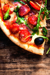 Hot pizza slice with Pepperoni, melting cheese on a rustic woode