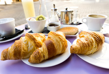 Breakfast with coffee and croissants on table