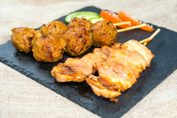 tasty grilled meat and vegetables skewers on a slate plate