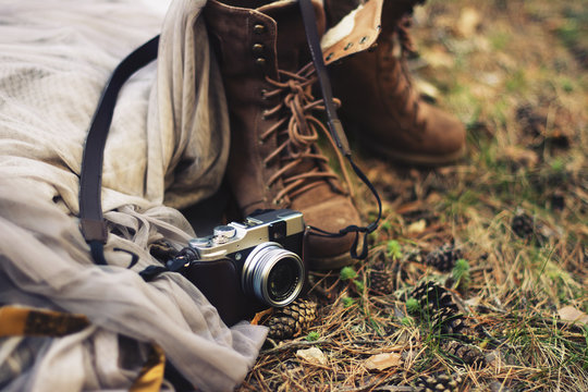 Shoes and camera in dried grass