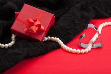 Red gift and white pearl necklace on black lace underwear