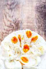 Hard boiled eggs, sliced in halves with black pepper spice on wh