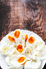 Hard boiled eggs, sliced in halves with black pepper spice on wo