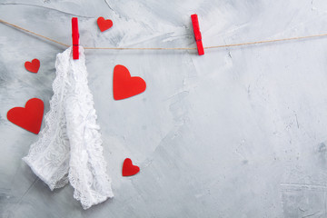 White lace underwear hanging onto clothespin on a rope.