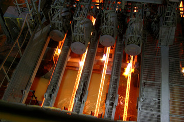 Steel continuous casting machine in operation with cutting equipoment in action.