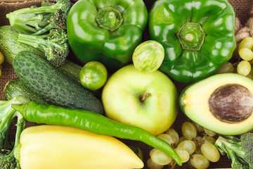 Set of green raw vegetables and fruits on the burlap