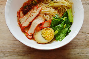 thin rice noodle topping slice red barbecue pork and brown egg in soup