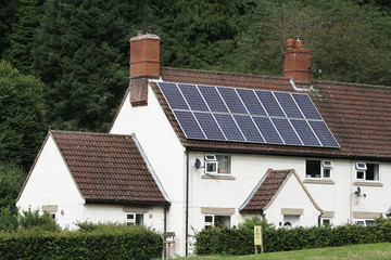 Cottage in countryside  with solar panels on the roof.
