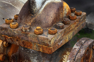 Rusting nuts and bolts on large cast steel valve flange.