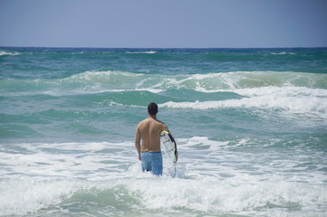 surfer goes with surfboard in the sea. Mediterranean Sea, Israel