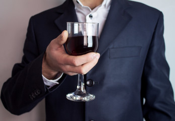 businessman holding glass of wine