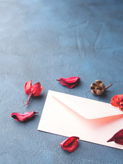 Pink envelope with dried flowers petals on dark blue background. Valentine's day. Sending Love letter
