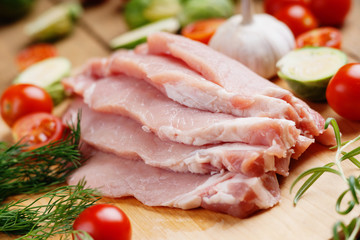 Slices of raw pork meat and vegetables 
