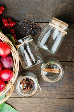 Plums in a basket, rowanberry and glass jars 