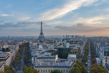 Fototapeta na wymiar View from Arc de Triomphe in Paris, France towards Eiffel Tower with skyline, blue sky and traffic