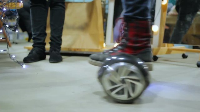 Customer testing battery-powered self-balancing scooter, having fun in mall