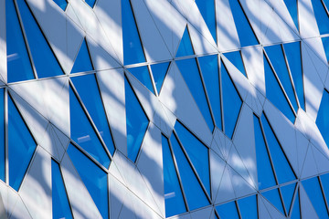 Blue toned sky reflection in the building window with sun and le